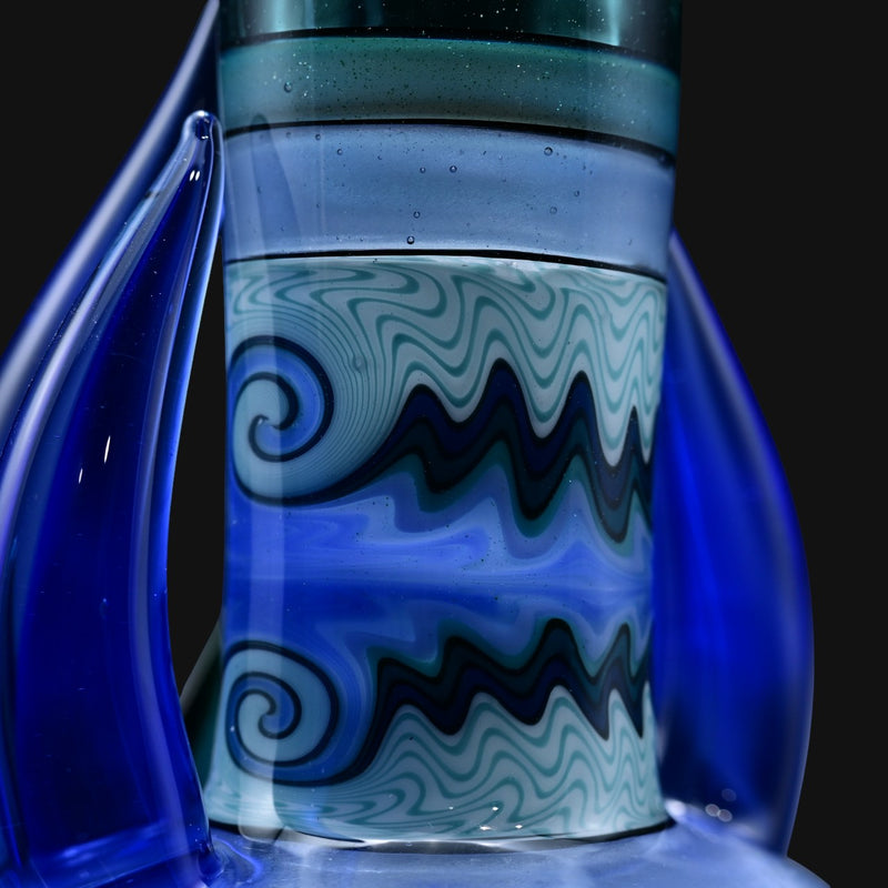 710 Pipes Smoke Shop Blossom Rig - Blue glass water pipe with swirling wave pattern and blue accents.