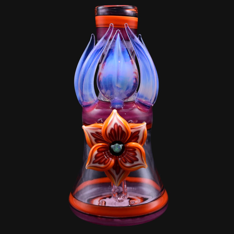 710 Pipes Smoke Shop Blossom Rig: a pink and orange glass rig with blue accents, featuring a floral design.
