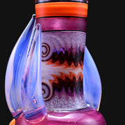 710 Pipes Smoke Shop Blossom Rig in pink, purple, orange, and blue glass with intricate swirling patterns and wavy accents.