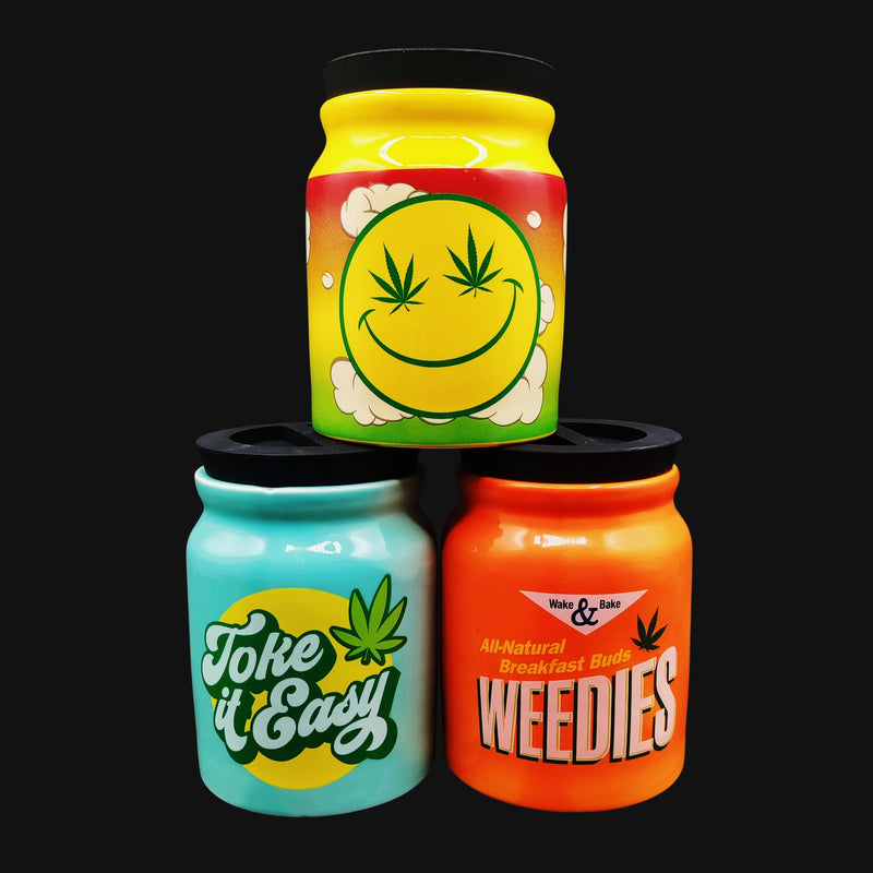 710 Pipes Smoke Shop ceramic stash jars featuring colorful stoner graphics and airtight lids in a stacked display.