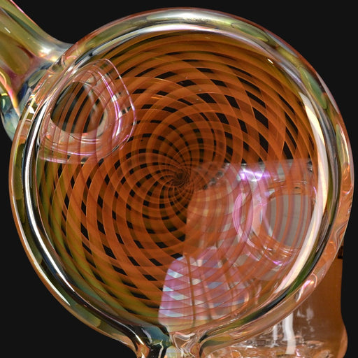 710 Pipes Smoke Shop fumed glass recycler featuring a detailed orange spiral disc pattern on a clear glass body