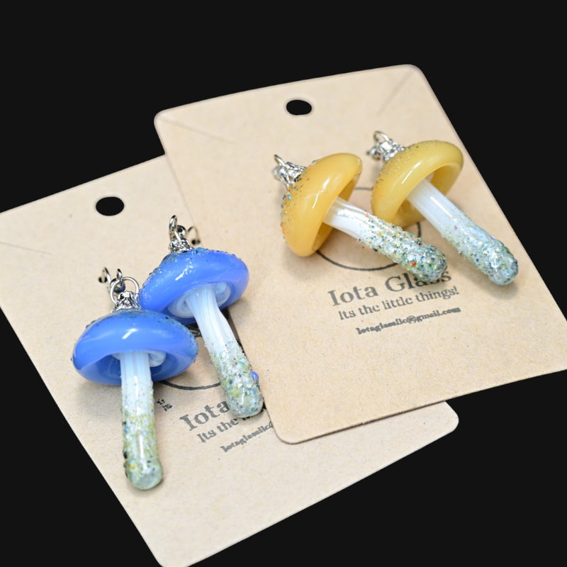710 Pipes Smoke Shop Iota mushroom earrings in blue and yellow glass with glittery stems on display cards