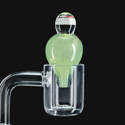710 Pipes Smoke Shop JuneBug Profane bubble cap in light green glass sitting in a clear quartz banger