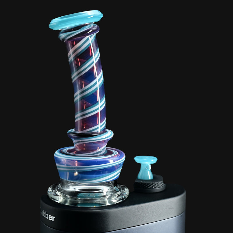 710 Pipes Smoke Shop Kadabra Switch2 glass attachment with purple and blue spiral stripes on a black background.