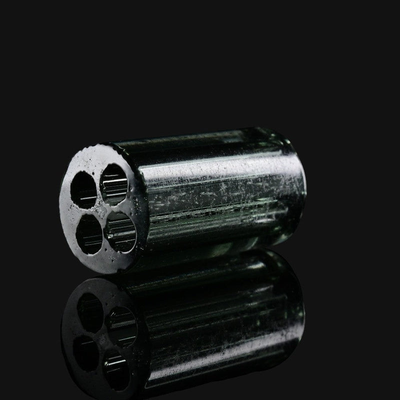 Kadabra black and UV glass tip from 710 Pipes Smoke Shop featuring a four-hole airflow design on a reflective surface.