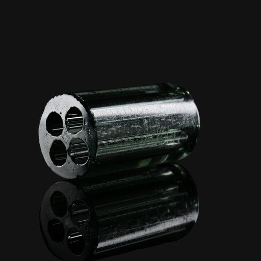 Kadabra black and UV glass tip from 710 Pipes Smoke Shop featuring a four-hole airflow design on a reflective surface.