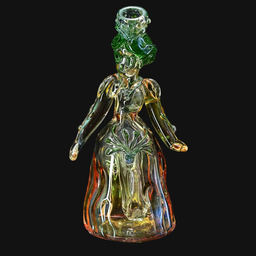 710 Pipes Smoke Shop Lyric Princess Rig, a unique glass pipe shaped like a woman with green hair and a flowing gown, accented with green and orange hues.