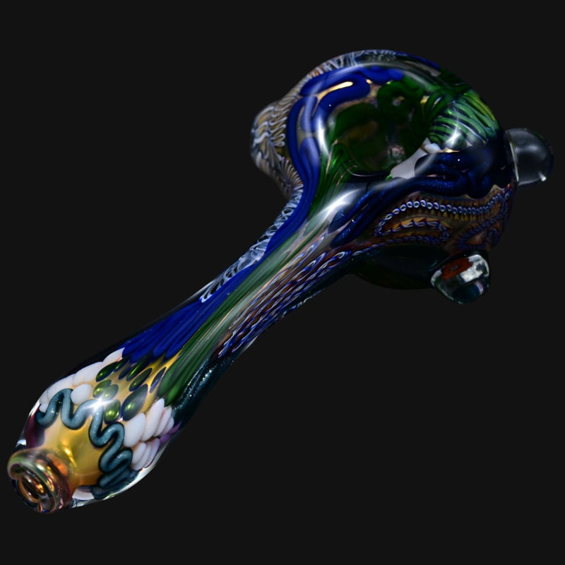 710 Pipes Smoke Shop Matty White thick glass spoon pipe featuring intricate blue, green, and gold patterned detailing.