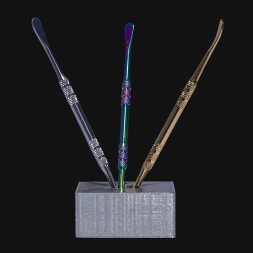 710 Pipes Smoke Shop stainless steel dab tools in silver, rainbow, and gold finishes with textured grips in a stand.