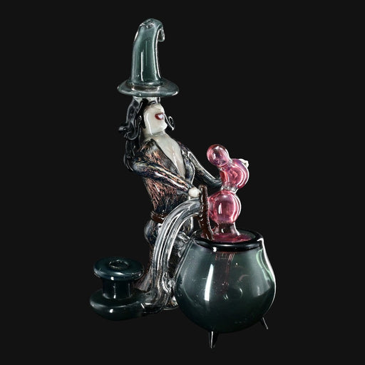 710 Pipes Smoke Shop Rich Villa "Witches Get Stoned" glass recycler rig with witch figure stirring cauldron, pink accents, and witch hat.