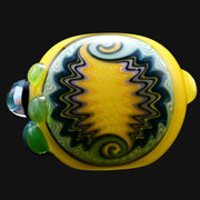 710 Pipes Smoke Shop yellow glass spoon pipe with wig wag pattern in blue, green, and purple. Features green glass accents.