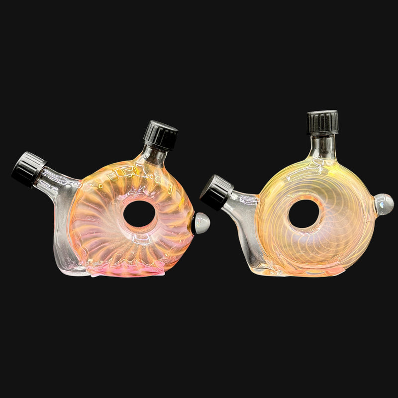 Two 710 Pipes Smoke Shop DeShields fume glass travel rigs with black joint and mouthpiece caps on a black background.