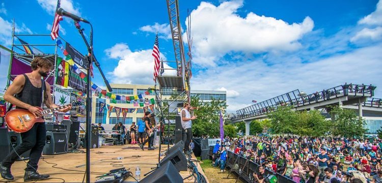 Musicians on-stage performing daytime show outdoors at HempFest in Seattle, Washington