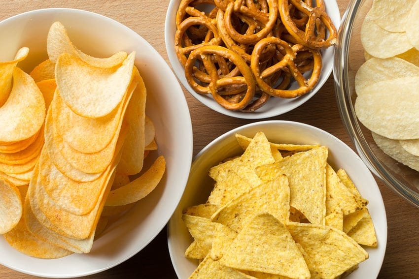 Bowls of pretzels, Pringles, Lays and corn chips