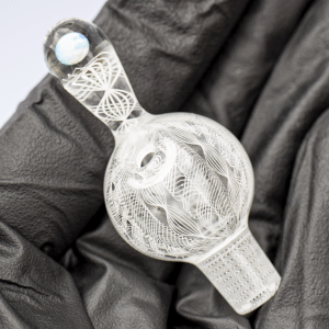 Mycomann engraved glass bubble cap with opal handle - held in palm of black gloved hand.
