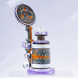 Multicolored dab rig with lavender base, striped neck, moonstone accents, and swirled design on chamber and mouthpiece.
