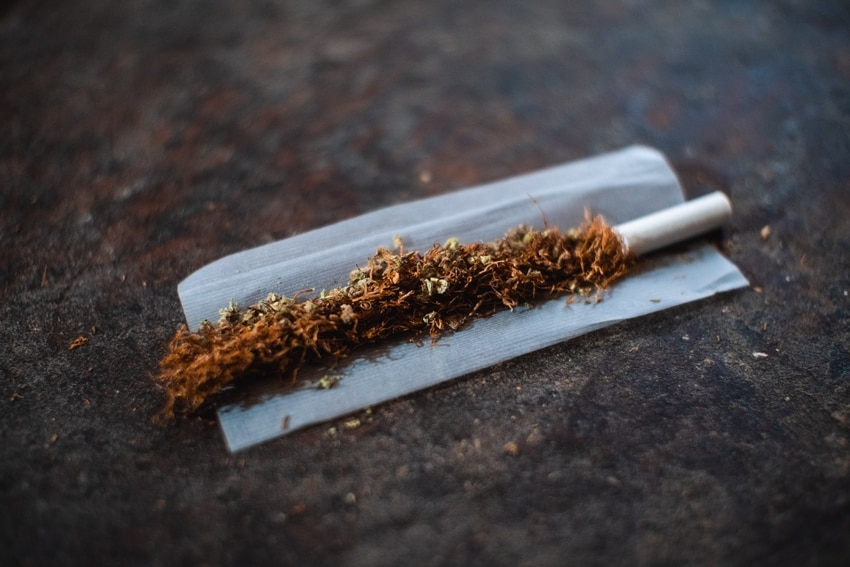 Rice Rolling Paper on Brown Table Holding Tobacco