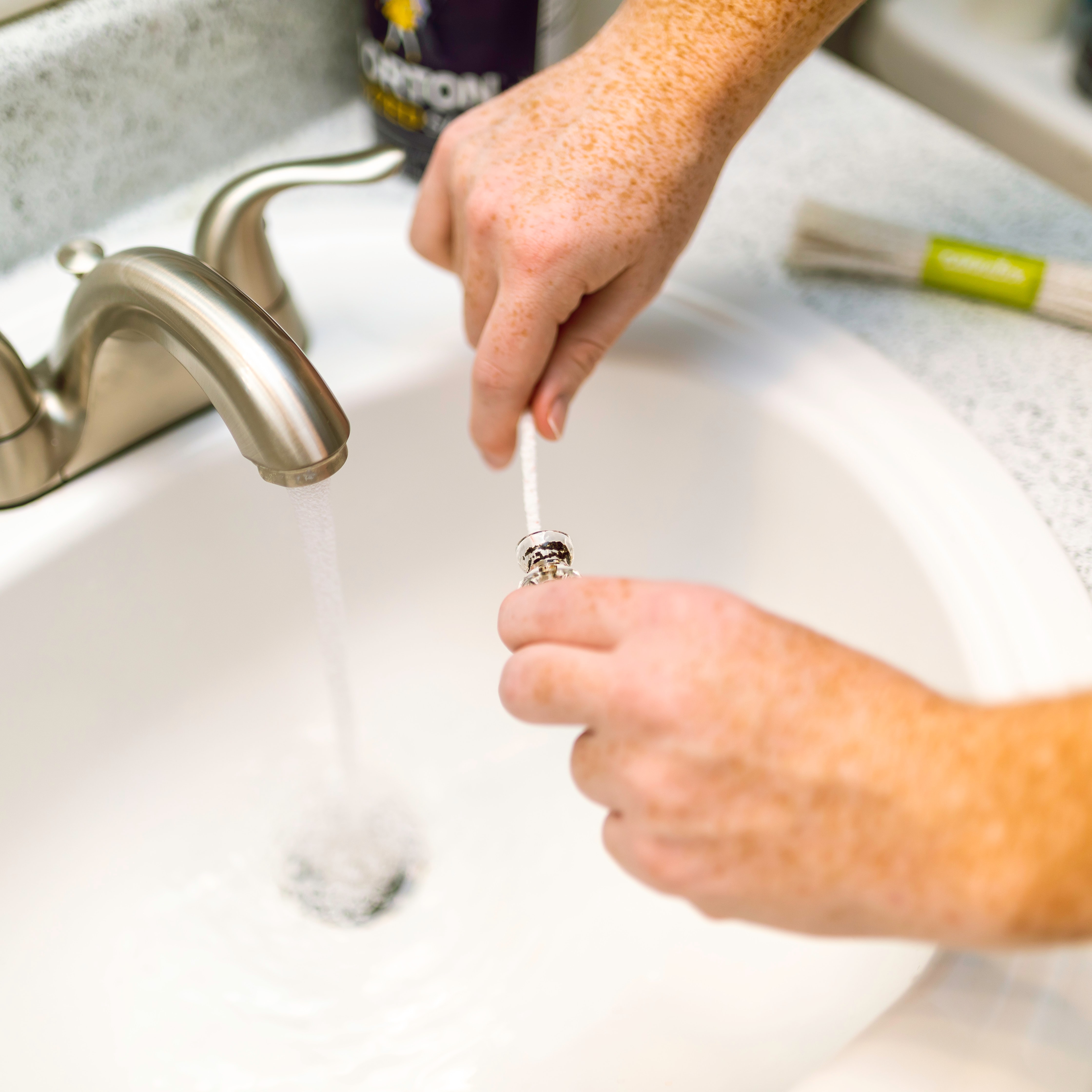 Man cleaning mouthpiece of heady glass honeycomb-themed water pipe using cotton swab