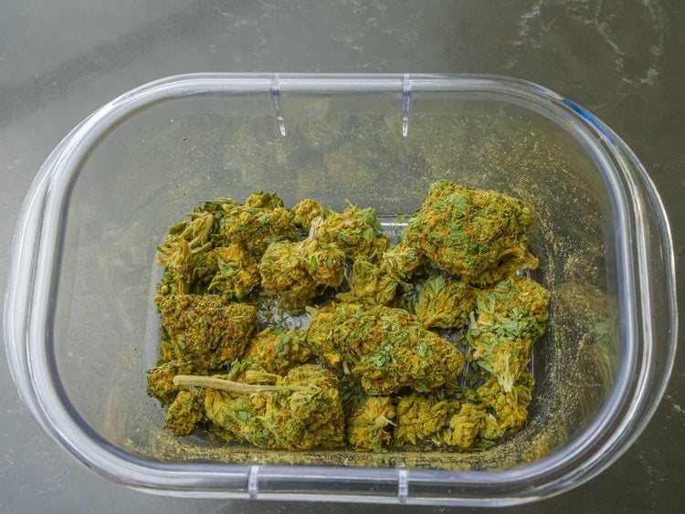 Cannabis nuggets inside of open storage container on table