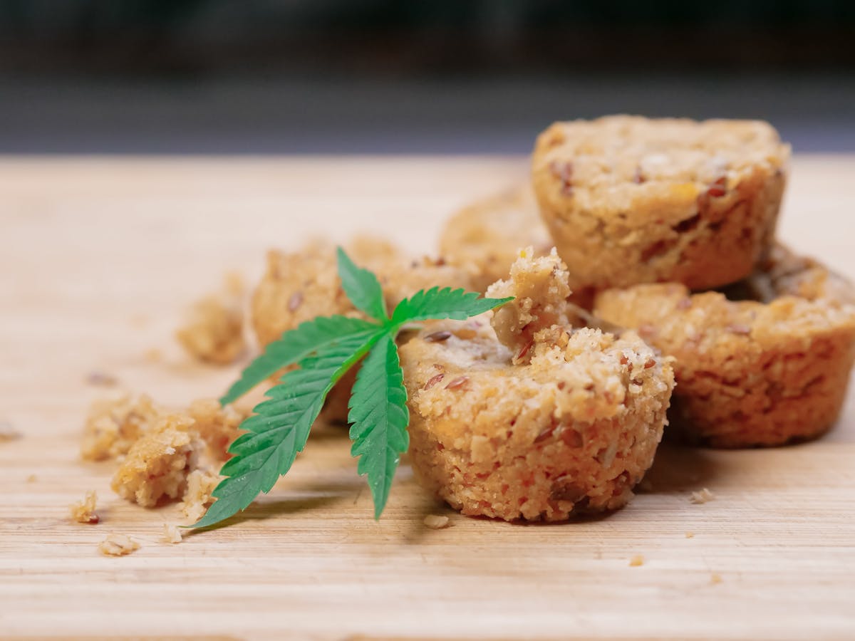 Cannabis cookies and pot leaf on oak table
