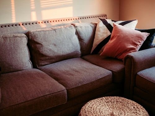 Comfortable brown couch with pillows in a cozy smoking room