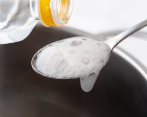 baking soda on a spoon with vinegar being poured onto it