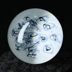 Kadabra Marble Experiment, white opal glass marble with dark swirl pattern, front view