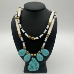 Tribal bead necklace in turquoise and white, shown on display stand