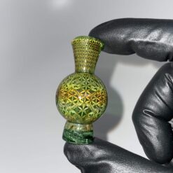 Mothership Bubble Cap 4, green glass spinner carb cap with a flower pattern, held in hand